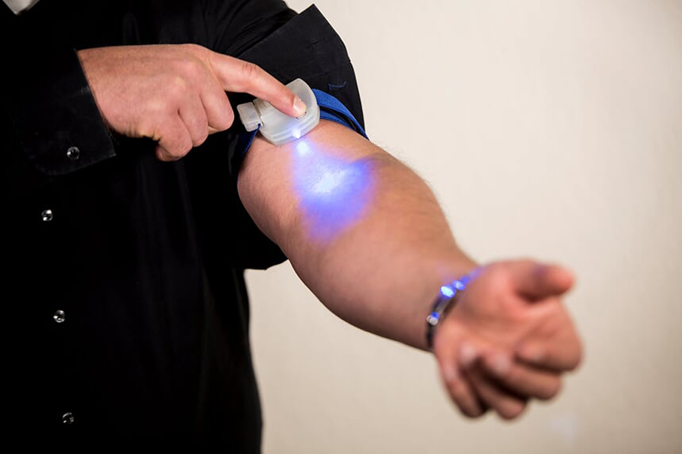 Man in an emergency situation at home using Tourniglo to examine his arm