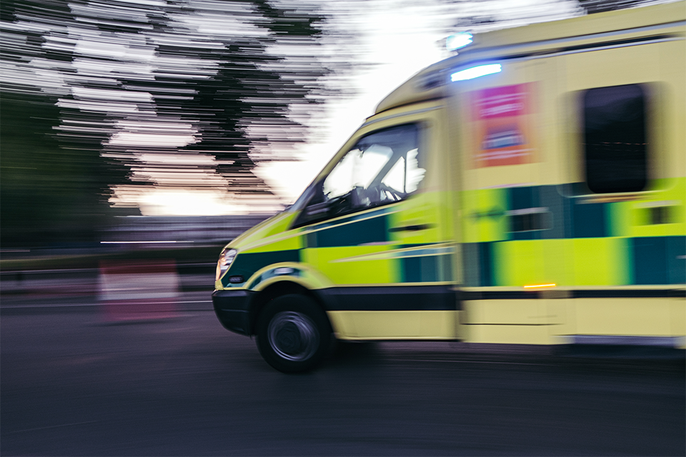 Ambulance driving quickly down a road.