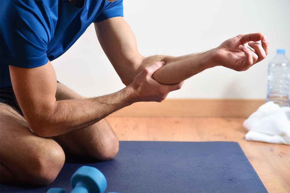 Man massaging his forearm as part of his post procedure recovery
